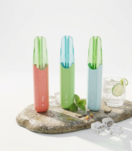 Three FLUM Float X 10K disposable vapes in red, green, and blue colors with a mint drink on ice